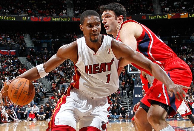 ATLANTA, GA - FEBRUARY 12:  Chris Bosh #1 of the Miami Heat drives around Zaza Pachulia #27 of the Atlanta Hawks at Philips Arena on February 12, 2012 in Atlanta, Georgia.  NOTE TO USER: User expressly acknowledges and agrees that, by downloading and or using this photograph, User is consenting to the terms and conditions of the Getty Images License Agreement.  (Photo by Kevin C. Cox/Getty Images)