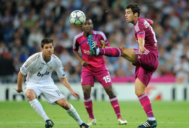 MADRID, SPAIN - OCTOBER 18: Miralem Pjanic (R) of Olympique Lyonnais controls the ball besides Xabi Alonso (L) of Real Madrid and Gueida Fofana of Olympique Lyonnais during the UEFA Champions League group D match between Real Madrid and Olympique Lyonnais at the Estadio Santiago Bernabeu on October 18, 2011 in Madrid, Spain.  (Photo by Jasper Juinen/Getty Images)