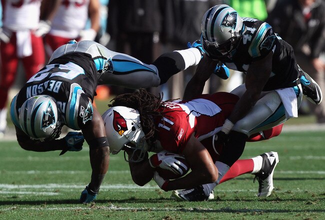 CHARLOTTE, NC - DECEMBER 19:  Larry Fitzgerald #11 of the Arizona Cardinals is tackled by teammates Captain Munnerlyn #41 and Jon Beason #52 of the Carolina Panthers during their game at Bank of America Stadium on December 19, 2010 in Charlotte, North Carolina.  (Photo by Streeter Lecka/Getty Images)