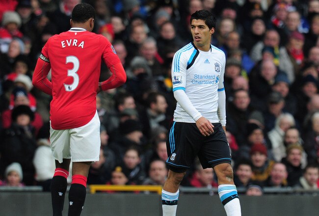 MANCHESTER, ENGLAND - FEBRUARY 11:  Luis Suarez of Liverpool looks at Patrice Evra of Manchester United during the Barclays Premier League match between Manchester United and Liverpool at Old Trafford on February 11, 2012 in Manchester, England.  (Photo by Shaun Botterill/Getty Images)