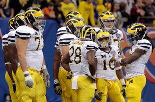 NEW ORLEANS, LA - JANUARY 03:  Quarterback Denard Robinson #16 (R) of the Michigan Wolverines calls a play in the offensive huddle against the Virginia Tech Hokies during the Allstate Sugar Bowl at Mercedes-Benz Superdome on January 3, 2012 in New Orleans, Louisiana.  (Photo by Chris Graythen/Getty Images)