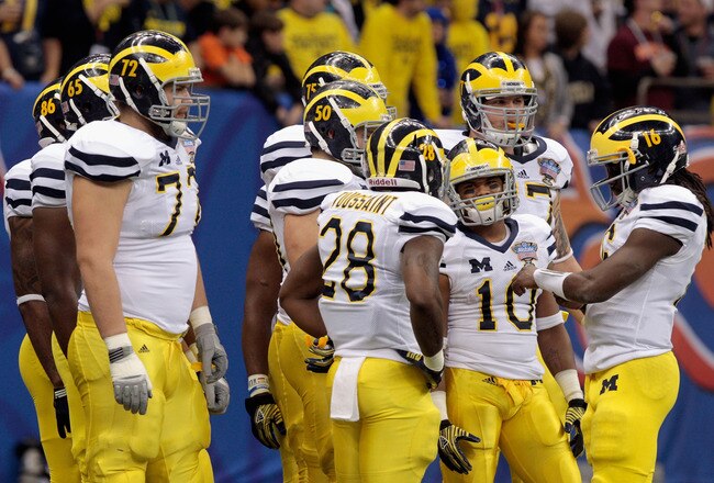 NEW ORLEANS, LA - JANUARY 03:  Quarterback Denard Robinson #16 (R) of the Michigan Wolverines calls a play in the offensive huddle against the Virginia Tech Hokies during the Allstate Sugar Bowl at Mercedes-Benz Superdome on January 3, 2012 in New Orleans, Louisiana.  (Photo by Chris Graythen/Getty Images)
