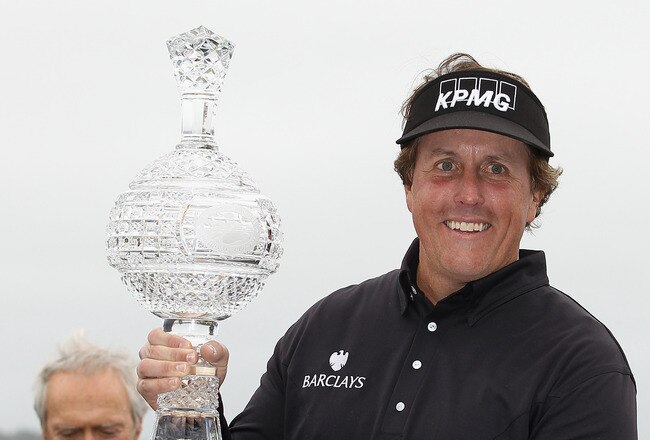 PEBBLE BEACH, CA - FEBRUARY 12:  Phil Mickelson is awarded with the tournament trophy after winning with an eight-under-par 64 as actor Clint Eastwood looks on during the AT&T Pebble Beach National Pro-Am at Pebble Beach Golf Links on February 12, 2012 in Pebble Beach, California.  (Photo by Ezra Shaw/Getty Images)