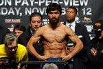LAS VEGAS, NV - NOVEMBER 11:  (C) Boxer Manny Pacquiao steps on the scale to weigh 143 pounds as trainer (L) Freddie Roach looks at the scale during the official weigh-in for his bout against Juan Manuel Marquez at the MGM Grand Garden Arena November 11, 2011 in Las Vegas, Nevada. Pacquiao will defend his WBO welterweight title against Marquez when the two meet in the ring for the third time on November 12 in Las Vegas.  (Photo by Ethan Miller/Getty Images)