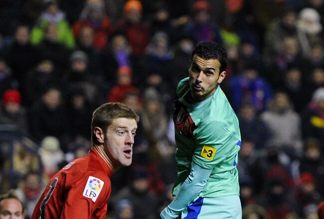 PAMPLONA, SPAIN - FEBRUARY 11:  Pedro Rodriguez of FC Barcelona (R) duels for a high ball with Sergio Fernandez of CA Osasuna during the La Liga match between CA Osasuna and FC Barcelona at the Reyno de Navarra Stadium on February 11, 2012 in Pamplona, Spain.  (Photo by David Ramos/Getty Images)
