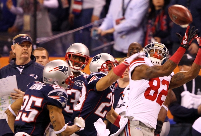 INDIANAPOLIS, IN - FEBRUARY 05:  Wide receiver Mario Manningham #82 of the New York Giants catches a 38-yard pass from Eli Manning #10 over Patrick Chung #25 and Sterling Moore #29 of the New England Patriots in the fourth quarter during Super Bowl XLVI at Lucas Oil Stadium on February 5, 2012 in Indianapolis, Indiana.  (Photo by Al Bello/Getty Images)