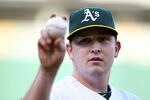 OAKLAND, CA - JUNE 14:  Starting pitcher Trevor Cahill #53 of the Oakland Athletics throws a ball to a fan against the Kansas City Royals at the Oakland-Alameda County Coliseum on June 14, 2011 in Oakland, California.  (Photo by Jed Jacobsohn/Getty Images)