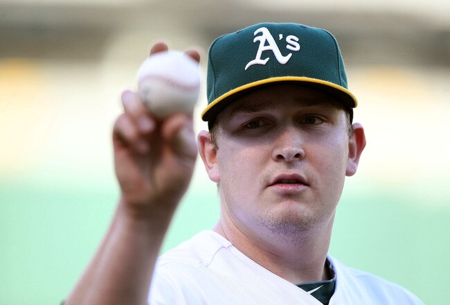 OAKLAND, CA - JUNE 14:  Starting pitcher Trevor Cahill #53 of the Oakland Athletics throws a ball to a fan against the Kansas City Royals at the Oakland-Alameda County Coliseum on June 14, 2011 in Oakland, California.  (Photo by Jed Jacobsohn/Getty Images)