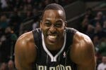 BOSTON, MA - JANUARY 17:  Dwight Howard #12 of the Orlando Magic smiles on the baseline as he waits for Shaquille O'Neal of the Boston Celtics to shoot a free throw on January 17, 2011 at the TD Garden in Boston, Massachusetts.  NOTE TO USER: User expressly acknowledges and agrees that, by downloading and/or using this Photograph, User is consenting to the terms and conditions of the Getty Images License Agreement.  (Photo by Elsa/Getty Images)