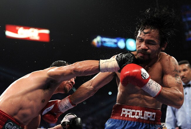 LAS VEGAS, NV - NOVEMBER 12:  (L-R) Juan Manuel Marquez throws a right to the head of Manny Pacquiao during the WBO world welterweight title fight at the MGM Grand Garden Arena on November 12, 2011 in Las Vegas, Nevada.  (Photo by Harry How/Getty Images)