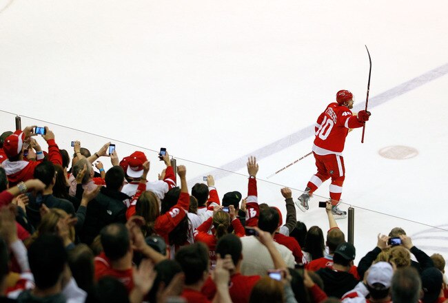DETROIT, MI - FEBRUARY 14: Henrik Zetterberg #40 of the Detroit Red Wings salutes fans as the first star of the game after the Red Wings NHL record breaking 21st consecutive home victory defeating the Dallas Stars 3-1 at Joe Louis Arena on February 14, 2012 in Detroit, Michigan. (Photo by Gregory Shamus/Getty Images)