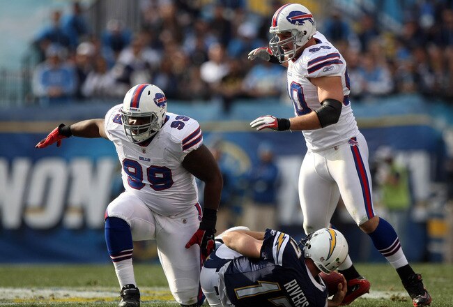 SAN DIEGO, CA - DECEMBER 11:  Quarterback Philip Rivers #17 of the San Diego Chargers is sacked by Marcell Dareus #99 and Chris Kelsay #90 of the Buffalo Bills during their NFL Game on December 11, 2011 at Qualcomm Stadium in San Diego, California. (Photo by Donald Miralle/Getty Images)