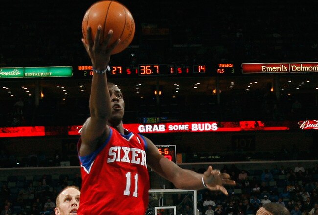 NEW ORLEANS, LA - JANUARY 04:  Jrue Holiday #11 of the Philadelphia 76ers makes a shot over Trey Johnson #12 of the New Orleans Hornets at New Orleans Arena on January 4, 2012 in New Orleans, Louisiana.  NOTE TO USER: User expressly acknowledges and agrees that, by downloading and or using this photograph, User is consenting to the terms and conditions of the Getty Images License Agreement.  (Photo by Chris Graythen/Getty Images)