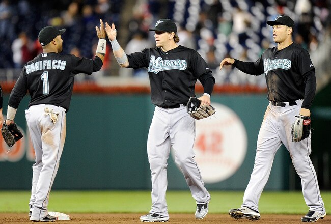 WASHINGTON, DC - SEPTEMBER 16:  Emilio Bonifacio #1, Logan Morrison #20 and Mike Stanton #27 of the Florida Marlins celebrate after a 3-0 victory against the Washington Nationals at Nationals Park on September 16, 2011 in Washington, DC.  (Photo by Greg Fiume/Getty Images)