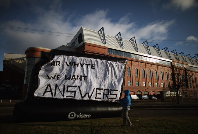 GLASGOW, SCOTLAND - FEBRUARY 15:  Rangers fan Michael Haggerty displays a banner outside directed to club owner Craig Whyte, outside the Ibrox Stadium on February 15, 2012 in Glasgow, Scotland. The Clydesdale Bank Premier League club entered administration yesterday over an unpaid tax bill of 9 million GBP.  (Photo by Jeff J Mitchell/Getty Images)