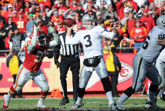KANSAS CITY, MO - DECEMBER 24:  Quarterback Carson Palmer #3 of the Oakland Raiders throws a pass down field against pressure from linebacker Tamba Hali #91 of the Kansas City Chiefs during the first half on December 24, 2011 at Arrowhead Stadium in Kansas City, Missouri.  (Photo by Peter Aiken/Getty Images)