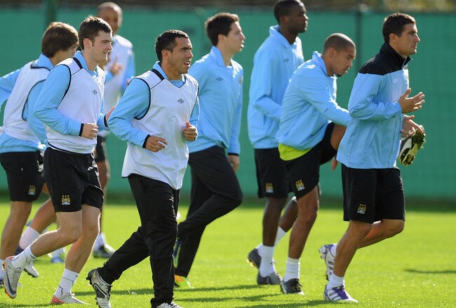 MANCHESTER, ENGLAND - SEPTEMBER 26: Adam Johnson (L), Carlos Tevez (2nd L) and Manchester City team-mates warm up during a training session ahead of their UEFA Champions League Group A match against Bayern Munich on September 26, 2011 in Manchester, United Kingdom.  (Photo by Michael Regan/Getty Images)