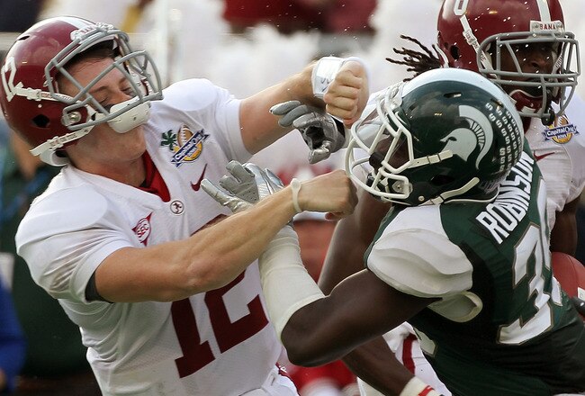 ORLANDO, FL - JANUARY 01:  Greg McElroy #12 of the Alabama Crimson Tide blocks Trenton Robinson #39 of  the Michigan State Spartans on a touchdown run during the Capitol One Bowl at the Florida Citrus Bowl on January 1, 2011 in Orlando, Florida.  (Photo by Mike Ehrmann/Getty Images)