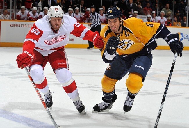 NASHVILLE, TN - DECEMBER 15:  Johan Franzen #93 of the Detroit Red Wings races Shea Weber #6 of the Nashville Predators for the puck at the Bridgestone Arena on December 15, 2011 in Nashville, Tennessee.  (Photo by Frederick Breedon/Getty Images)