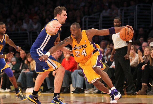 LOS ANGELES, CA - JANUARY 06:  Kobe Bryant #24 of the Los Angeles Lakers drives against David Lee #10 of the Golden State Warriors  at Staples Center on January 6, 2012 in Los Angeles, California.  The Lakers won 97-90. NOTE TO USER: User expressly acknowledges and agrees that, by downloading and or using this photograph, User is consenting to the terms and conditions of the Getty Images License Agreement.  (Photo by Stephen Dunn/Getty Images)
