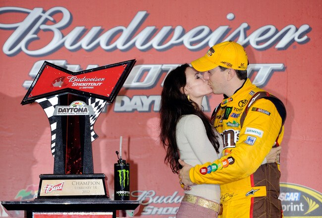 DAYTONA BEACH, FL - FEBRUARY 18:  Kyle Busch (R), driver of the #18 M&M's Brown Toyota, kisses his wife Samantha Busch (L) in Victory Lane after winning the NASCAR Budweiser Shootout at Daytona International Speedway on February 18, 2012 in Daytona Beach, Florida.  (Photo by John Harrelson/Getty Images for NASCAR)