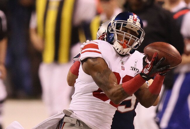 INDIANAPOLIS, IN - FEBRUARY 05:  Mario Manningham #82 of the New York Giants makes a catch on the sidelines against Sterling Moore #29 of the New England Patriots for a gain of 39 yards in the fourth quarter during Super Bowl XLVI at Lucas Oil Stadium on February 5, 2012 in Indianapolis, Indiana.  (Photo by Win McNamee/Getty Images)