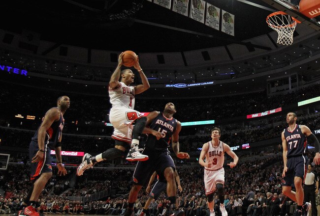 CHICAGO, IL - JANUARY 03:  Derrick Rose #1 of the Chicago Bulls drives to the basket between Tracy McGrady #1 and Al Horford #15 of the Atlanta Hawks at the United Center on January 3, 2012 in Chicago, Illinois. The Bulls defeated the Hawks 76-74. NOTE TO USER: User expressly acknowledges and agrees that, by downloading and or using this photograph, User is consenting to the terms and conditions of the Getty Images License Agreement.  (Photo by Jonathan Daniel/Getty Images)