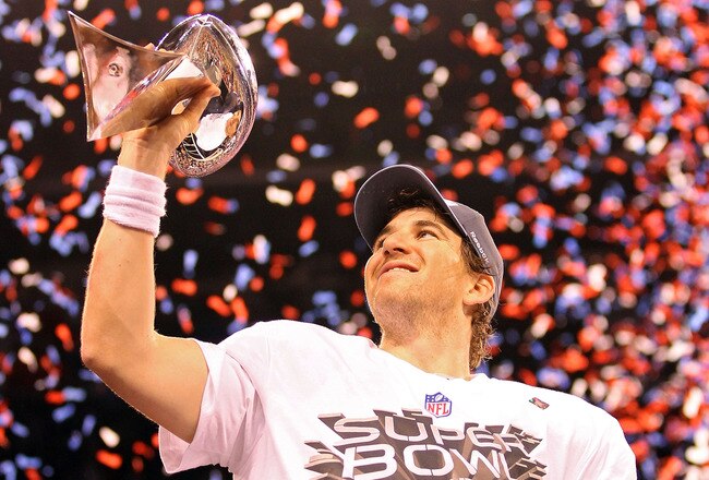 INDIANAPOLIS, IN - FEBRUARY 05:  Quarterback Eli Manning #10 of the New York Giants poses with the Vince Lombardi Trophy after the Giants defeated the Patriots by a score of 21-17 in Super Bowl XLVI at Lucas Oil Stadium on February 5, 2012 in Indianapolis, Indiana.  (Photo by Ezra Shaw/Getty Images)