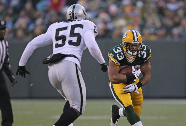 GREEN BAY, WI - DECEMBER 11: Brandon Saine #33 of the Green Bay Packers runs as Rolando McClain #55 of the Oakland Raiders closes in at Lambeau Field on December 11, 2011 in Green Bay, Wisconsin. The Packers defeated the Raiders 46-16. (Photo by Jonathan Daniel/Getty Images)