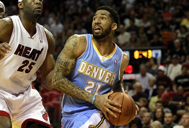 MIAMI, FL - MARCH 19:  Forward Wilson Chandler #21 of the Denver Nuggets drives against Center Erick Dampier #25 of the Miami Heat at American Airlines Arena on March 19, 2011 in Miami, Florida.  The Heat defeated the Nuggets 103-98. NOTE TO USER: User expressly acknowledges and agrees that, by downloading and/or using this Photograph, User is consenting to the terms and conditions of the Getty Images License Agreement.  (Photo by Marc Serota/Getty Images)