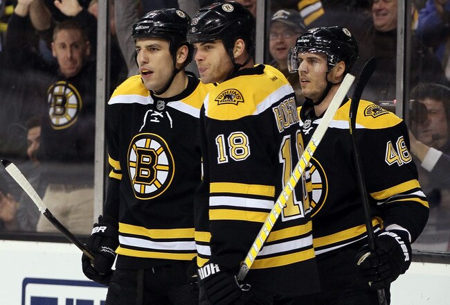 BOSTON, MA - JANUARY 05:  David Krejci #46 of the Boston Bruins is congratulated by teammates Milan Lucic #117 and Nathan Horton #18 after Krejci scored in the second period against the Calgary Flames on January 5, 2012 at TD Garden in Boston, Massachusetts.  (Photo by Elsa/Getty Images)