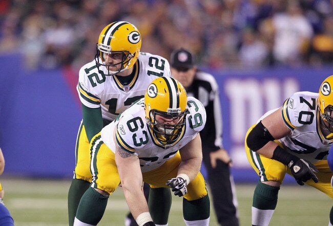 EAST RUTHERFORD, NJ - DECEMBER 04:  Aaron Rodgers #12 of the Green Bay Packers calls signals out as he stands at the line of scrimmage behind center Scott Wells #63 of the Green Bay Packers against the New York Giants at MetLife Stadium on December 4, 2011 in East Rutherford, New Jersey. The Packers won 38-35.  (Photo by Nick Laham/Getty Images)