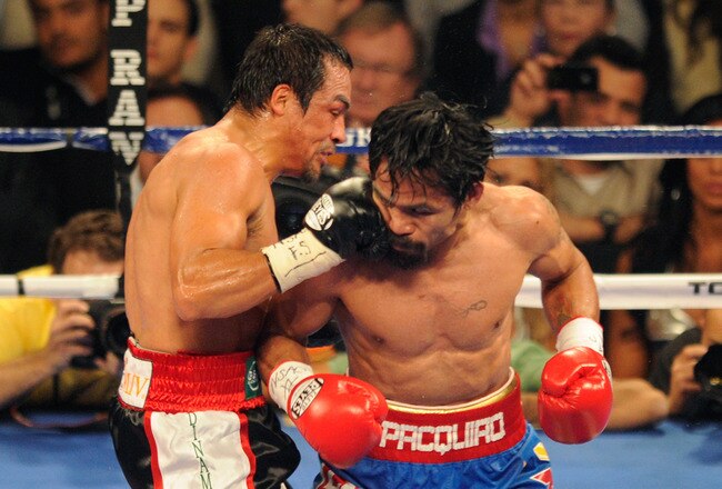LAS VEGAS, NV - NOVEMBER 12:  (L-R) Juan Manuel Marquez connects with a right to the face of Manny Pacquiao during the WBO world welterweight title fight at the MGM Grand Garden Arena on November 12, 2011 in Las Vegas, Nevada.  (Photo by Ethan Miller/Getty Images)