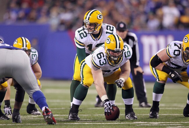EAST RUTHERFORD, NJ - DECEMBER 04:  Aaron Rodgers #12 of the Green Bay Packers calls signals out as he stands at the line of scrimmage behind center Scott Wells #63 of the Green Bay Packers against the New York Giants at MetLife Stadium on December 4, 2011 in East Rutherford, New Jersey. The Packers won 38-35.  (Photo by Nick Laham/Getty Images)