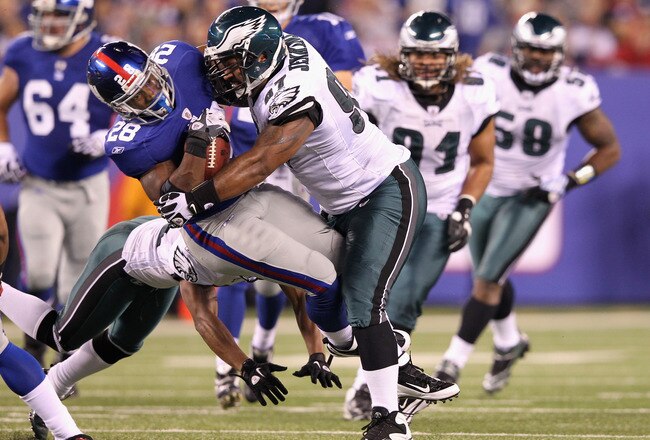EAST RUTHERFORD, NJ - NOVEMBER 20:  D.J. Ware #28 of the New York Giants is hit by Cullen Jenkins #97 of the Philadelphia Eagles in the second quarter at MetLife Stadium on November 20, 2011 in East Rutherford, New Jersey.  (Photo by Al Bello/Getty Images)