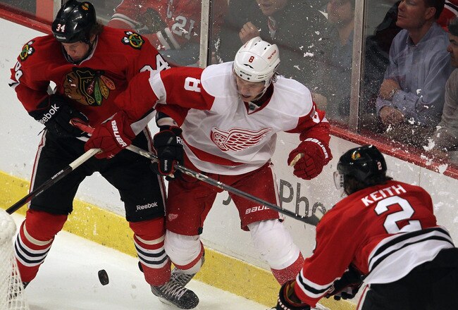 CHICAGO, IL - FEBRUARY 21: Dylan Olsen #34 and Duncan Keith #2 of the Chicago Blackhawks defend behind the net against Justin Abdelkader #8 of the Detroit Red Wings at the United Center on February 21, 2012 in Chicago, Illinois. The Blackhawks defeated the Red Wings 2-1. (Photo by Jonathan Daniel/Getty Images)