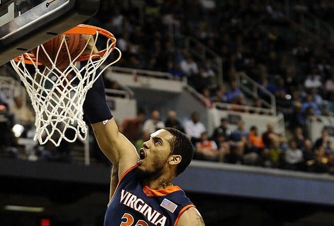 GREENSBORO, NC - MARCH 12:  Mike Scott #32 of the University of Virginia Cavaliers drives by Miles Plumlee #21 and Kyle Singler #12  of the Duke Blue Devils guards in their quarterfinal game in the 2010 ACC Men's Basketball Tournament at the Greensboro Coliseum on March 12, 2010 in Greensboro, North Carolina.  (Photo by Jeff Zelevansky/Getty Images)