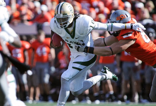 STILLWATER, OK - OCTOBER 29:  Quarterback Robert Griffin III #10 of the Baylor Bears is grabbed by defensive end Cooper Bassett #80 of Oklahoma State Cowboys in the first half October 29, 2011 at Boone Pickens Stadium in Stillwater, Oklahoma.  Oklahoma State leads Baylor 35-0 at the half.   (Photo by Brett Deering/Getty Images)