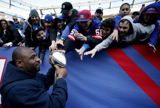 EAST RUTHERFORD, NJ - FEBRUARY 07:  Brandon Jacobs #27 of the New York Giants shares the Vince Lombardi Trophy with fans at a rally to celebrate the New York Giants' Super Bowl victory at MetLife Stadium on February 7, 2012 in East Rutherford, New Jersey. The Giants defeated the New England Patriots 21-17 in Super Bowl XLVI at Lucas Oil Stadium on February 5, 2012 in Indianapolis, Indiana.  (Photo by Jeff Zelevansky/Getty Images)