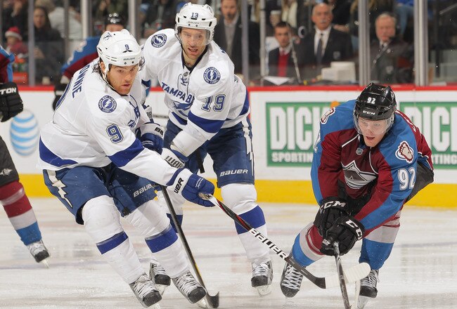 DENVER, CO - DECEMBER 23:  Steve Downie #9 of the Tampa Bay Lightning and Gabriel Landeskog #92 of the Colorado Avalanche battle for control of the puck at the Pepsi Center on December 23, 2011 in Denver, Colorado. The Avalanche defeated the Lightning 2-1 in overtime.  (Photo by Doug Pensinger/Getty Images)