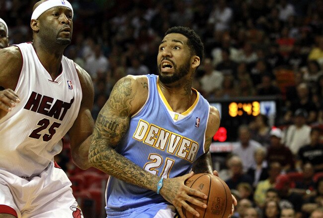 MIAMI, FL - MARCH 19:  Forward Wilson Chandler #21 of the Denver Nuggets drives against Center Erick Dampier #25 of the Miami Heat at American Airlines Arena on March 19, 2011 in Miami, Florida.  The Heat defeated the Nuggets 103-98. NOTE TO USER: User expressly acknowledges and agrees that, by downloading and/or using this Photograph, User is consenting to the terms and conditions of the Getty Images License Agreement.  (Photo by Marc Serota/Getty Images)