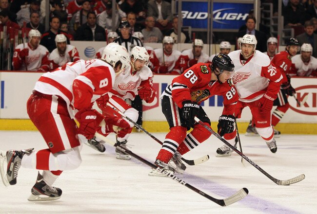 CHICAGO, IL - FEBRUARY 21: Patrick Kane #88 of the Chicago Blackhawks splits defenders (L-R) Justin Abdelkader #8, Darren Helm #43 and Drew Miller #20 of the Detroit Red Wings at the United Center on February 21, 2012 in Chicago, Illinois.  (Photo by Jonathan Daniel/Getty Images)