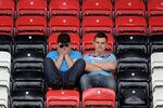 WIGAN, ENGLAND - MAY 15:  West Ham United fans look dejected following their relegation at the end of the Barclays Premier League match between Wigan Athletic and West Ham United at the DW Stadium on May 15, 2011 in Wigan, England.  (Photo by Chris Brunskill/Getty Images)