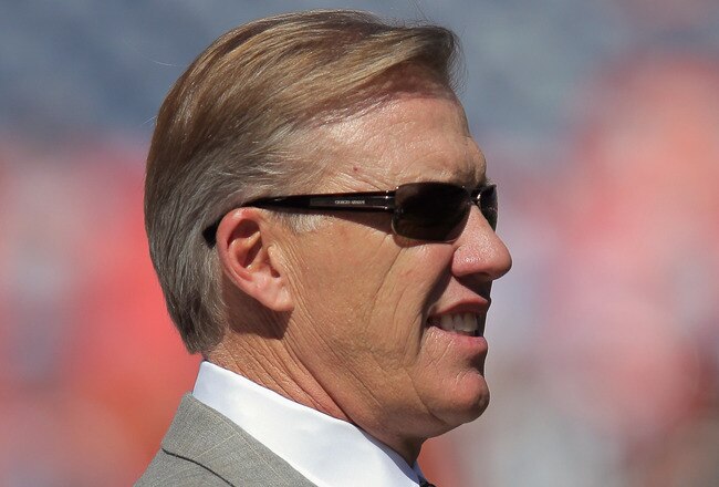 DENVER, CO - SEPTEMBER 18:  John Elway, Executive Vice President of Football Operations for the Denver Broncos, looks on from the bench as the Broncos warm up prior to facing the Cincinnati Bengals at Invesco Field at Mile High on September 18, 2011 in Denver, Colorado. The Broncos defeated the Bengals 24-22.  (Photo by Doug Pensinger/Getty Images)