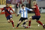 EAST RUTHERFORD, NJ - MARCH 26:  Lionel Messi #10 of Argentina dribbles between Landon Donovan #10 and Michael Bradley #4 of the United States during the first half of a friendly match at New Meadowlands Stadium on March 26, 2011 in East Rutherford, New Jersey.  (Photo by Jeff Zelevansky/Getty Images)