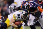 DENVER, CO - JANUARY 08: Heath Miller #83 of the Pittsburgh Steelers runs the ball against Brodrick Bunkley #77 of the Denver Broncos during the AFC Wild Card Playoff game at Sports Authority Field at Mile High on January 8, 2012 in Denver, Colorado. The Denver Broncos defeated the the Pittsburgh Steelers in overtime 23 - 29.   (Photo by Doug Pensinger/Getty Images)