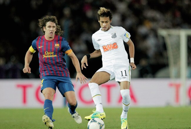 YOKOHAMA, JAPAN - DECEMBER 18:  Neymar (R) of Santos challenged by Carles Puyol of FC Barcelona during the FIFA Club World Cup Final match between Santosl and Barcelona at the Yokohama International Stadium on December 18, 2011 in Yokohama, Japan.  (Photo by Lintao Zhang/Getty Images)