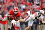ATHENS, GA - NOVEMBER 12:  Bacarri Rambo #18 of the Georgia Bulldogs intercepts a pass intended for Dimitri Reese #84 of the Auburn Tigers and returns it for a touchdown at Sanford Stadium on November 12, 2011 in Athens, Georgia.  (Photo by Kevin C. Cox/Getty Images)