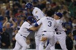 LOS ANGELES, CA - AUGUST 12:  Matt Kemp #27 of the Los Angeles Dodgers is mobbed by Aaron Miles #6, Eugenio Velez #3, and Justin Sellers #12 after hitting a walk off RBI single in the tenth inning against  the Houston Astros on August 12, 2011 at Dodger Stadium in Los Angeles, California. The Dodgers won 1-0.  (Photo by Stephen Dunn/Getty Images)