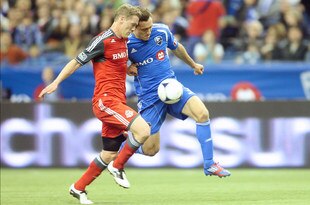 MONTREAL, CANADA - APRIL 7:  Andrew Wenger #33 of the Montreal Impact moves the ball past Ty Harden #20 of the Toronto FC during the MLS match at the Olympic Stadium on April 7, 2012 in Montreal, Quebec, Canada.  The Impact defeated the Toronto FC 2-1.  (Photo by Richard Wolowicz/Getty Images)